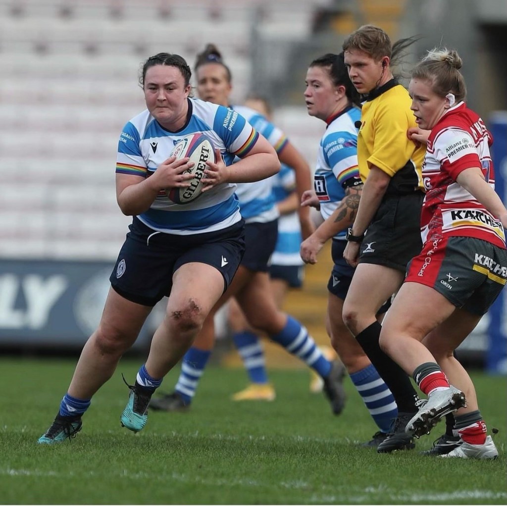 Jasmine Hazell carrying the ball for DMP Sharks as Sam watches in the background.