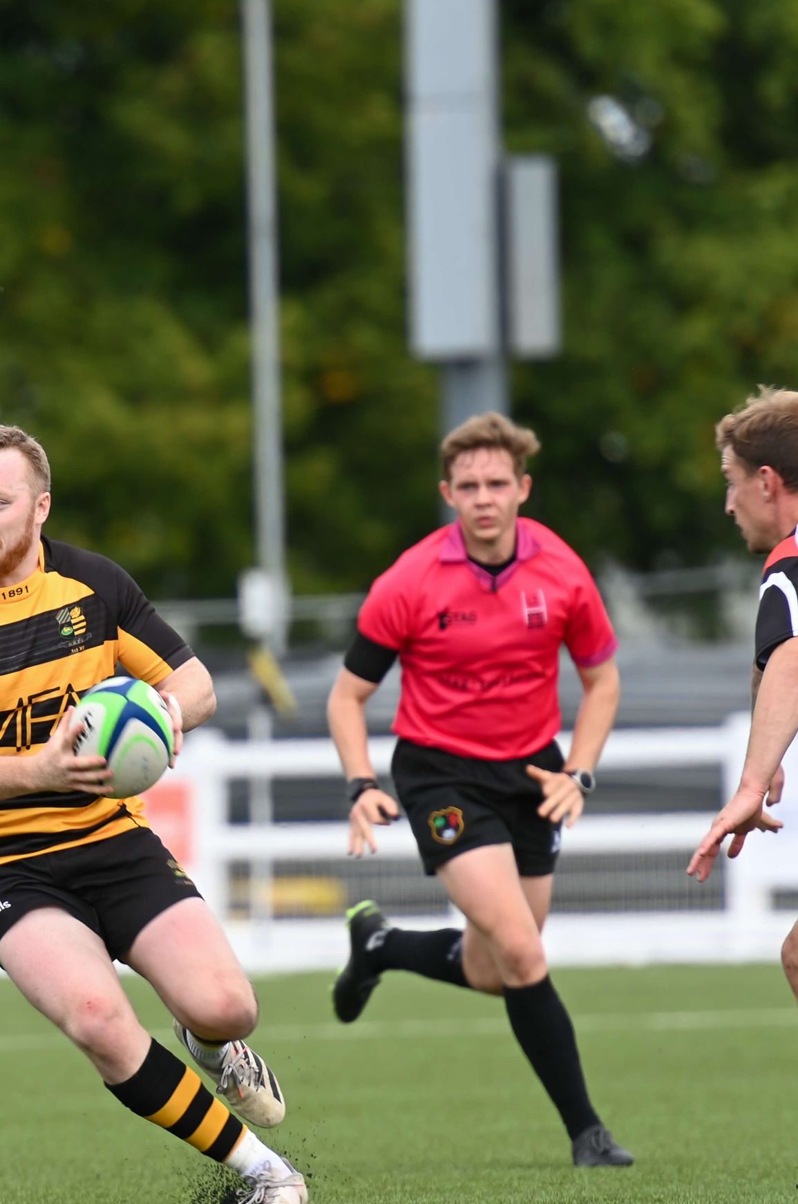 Photo showing Sam running just behind the ball carrier while refereeing a recent match.